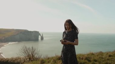 Okyanustaki ya da deniz kıyısındaki bir kayanın üzerinde İncil okuyan genç bir kız Tanrı 'ya şükran ve sevgiyle Tanrı' nın sözlerini güzel bir manzarayla okuyor. Kameraya bakıp manzaranın tadını çıkarıyorum.