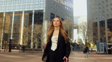 Genç ve çekici bir kadın bir toplantıya ya da işe gitmek için acele ediyor, akıllı telefonundaki saate bakıyor ve Paris 'in iş merkezindeki cadde boyunca koşuyor.