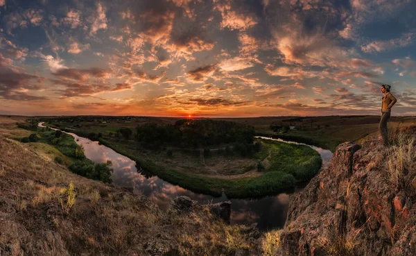 A traveler enjoys a panoramic view of the Kalmius river bend during sunset in Starolaspa, Ukraine.