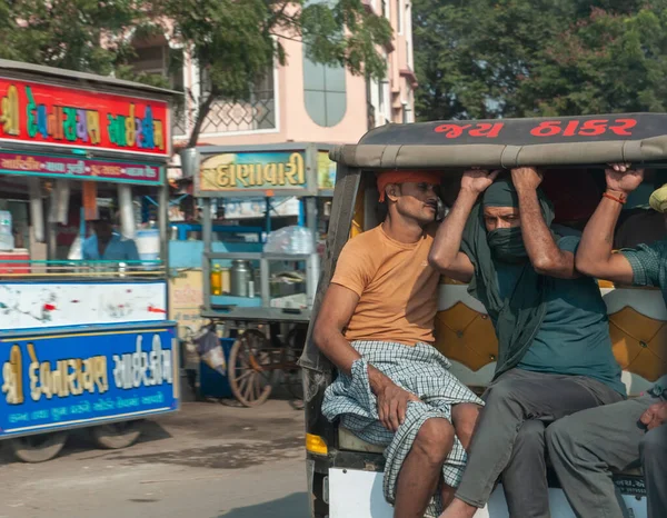Morbi, Gujarat, India - 12 02 2022: A fully loaded rickish or tuk-tuk carrying rural passengers along the road.