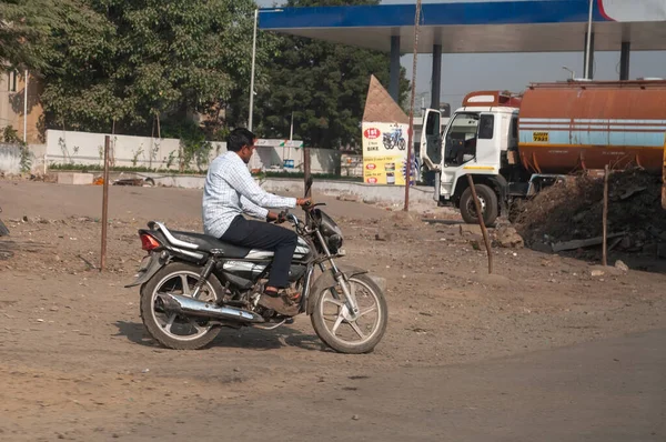 Morbi, Gujarat, India - 12 02 2022: A man without helmet rides motorbike along indian city street.
