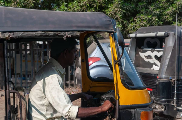 Gandhidham, Gujarat, India - 12 02 2022: Rikisha or tuk tuk driver while driving his tricycle.