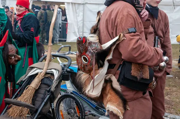 Hohenstadt - February 17, 2023: Participant of a parade with mask at the traditional carnival parade in Hohenstadt, Germany. The mask has been taken off and is hanging on the back.