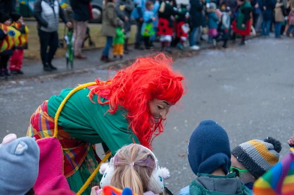 Hohenstadt - February 17, 2023: Participants of a parade with traditional costumes at the carnival parade in Hohenstadt, Germany. Distribute sweets to children