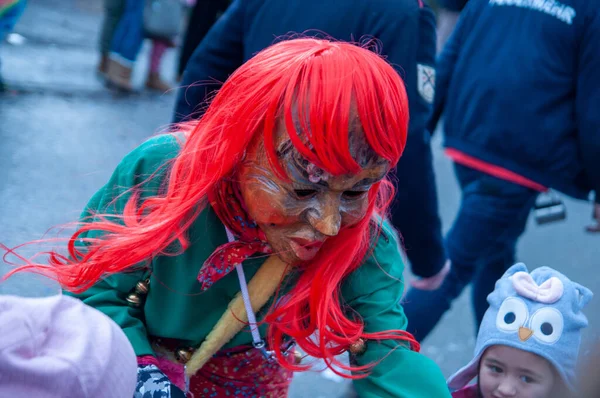 Hohenstadt - February 17, 2023: Participants of a parade with traditional costumes at the carnival parade in Hohenstadt, Germany. Distribute sweets to children