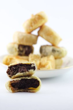 Bakpia Pathok. Indonesian traditional cake. Close up of handmade steamed cakes. various flavors. served on a plate, white background. isolated, photography studio.