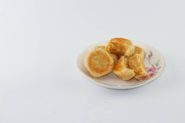 Bakpia Pathok. Indonesian traditional cake. Close up of handmade steamed cakes. various flavors. served on a plate, white background. isolated, photography studio.