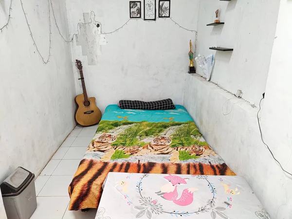 Klaten, Indonesia - December 2022 : neat and clean room atmosphere. a bed to lie down to unwind in the house. real life. white floor and white walls.