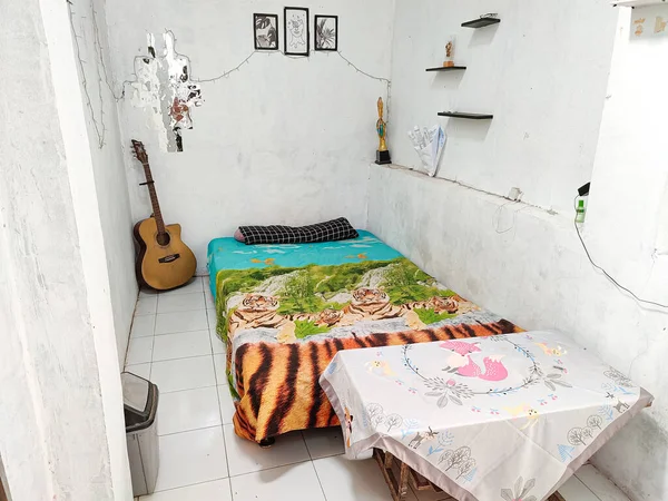 Klaten, Indonesia - December 2022 : neat and clean room atmosphere. a bed to lie down to unwind in the house. real life. white floor and white walls.
