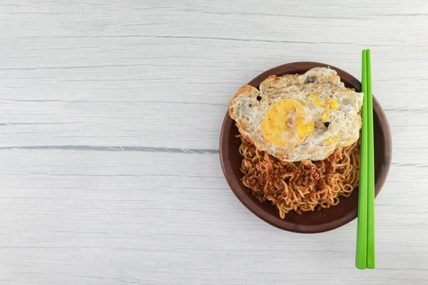 Çırpılmış yumurtayla karıştırılmış hazır şehriye. Çamurdan yapılmış toprak tabaklarda servis edilir. Beyaz arka plan. yukarıdan.