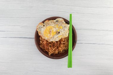 Çırpılmış yumurtayla karıştırılmış hazır şehriye. Çamurdan yapılmış toprak tabaklarda servis edilir. Beyaz arka plan. yukarıdan.