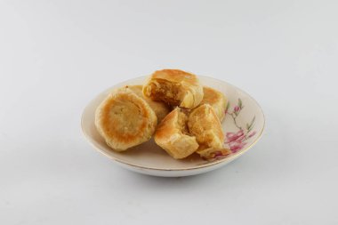 Bakpia Pathok. Indonesian traditional cake. Close up of handmade steamed cakes. various flavors. served on a plate, white background. isolated, photography studio.