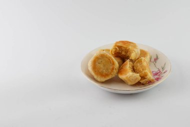 Bakpia Pathok. Indonesian traditional cake. Close up of handmade steamed cakes. various flavors. served on a plate, white background. isolated, photography studio.