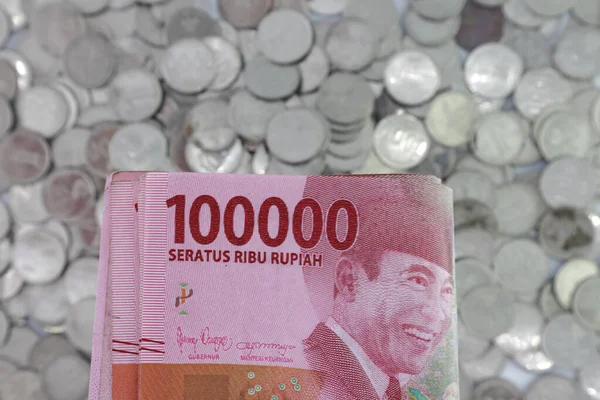 Indonesian rupiah currency. close up One hundred thousand rupiah. 100000 rupiahs. with the concept of being held by hand. receive financial assistance. white background. isolated, studio photography.