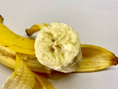 Peeled broken fresh banana with peel close-up.