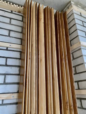 Painted wood boards standing in the corner of the brick wall