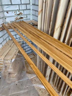 Painting of wooden boards and other products with brown varnish for further work at the construction site