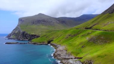 Faroe Adası yolu güzel sahil boyunca uzanıyor. Faroe Vagar Adası, Danimarka. Ön hava uçuşu. Yüksek kalite 4k görüntü