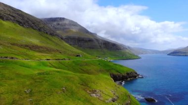 Faroe Adası yolu güzel sahil boyunca uzanıyor. Faroe Vagar Adası, Danimarka. Ön hava uçuşu. Yüksek kalite 4k görüntü