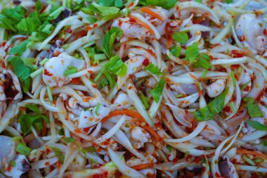 Acı biber, soğan, sarımsak ve taze soğandan oluşan baharatlı salata, kişniş, karıştırılmış..