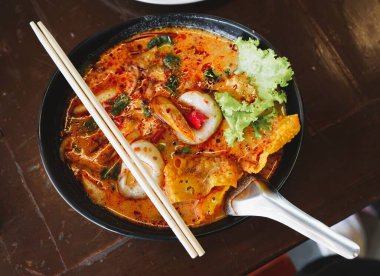 Yemek çubukları ve kaşıklar Tom yum kasesinin üstüne konur..