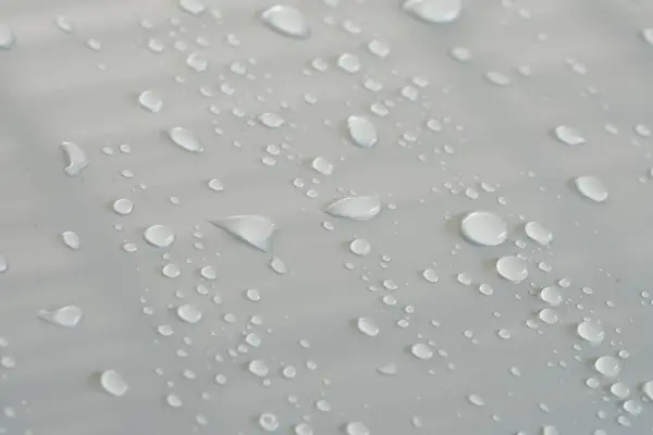 Water beads that form on the gray-white surface.