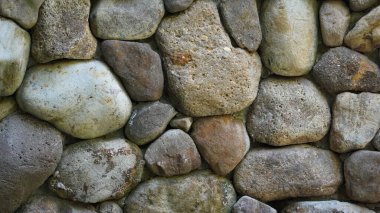 Arkaplan resmi: Taştan bir duvar oluşturmak için büyük kayalar bir araya getirildi.
