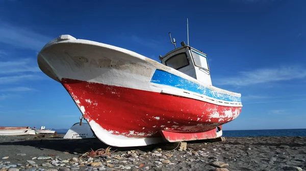Güzel bir teknenin açılı görüntüsü kumsalın kumları üzerinde mavi ve kırmızı renklerle