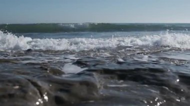 Yavaş çekim deniz dalgaları kayalara çarpıyor.