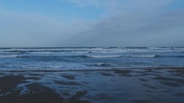 general shot of a beach practicing windsurfing