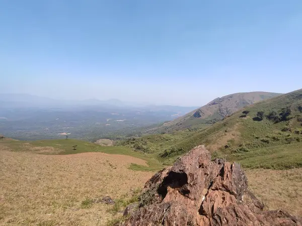 Virajlı yolu ve park etmiş arabaları olan dağlık arazinin havadan görünüşü.