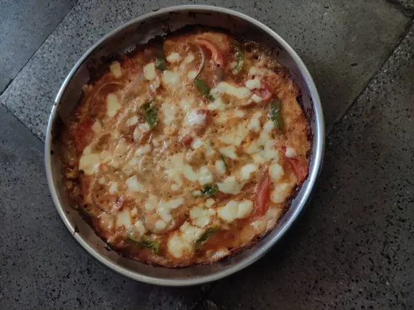 Döşeme üzerinde peynirli ve domatesli ev yapımı pizza..