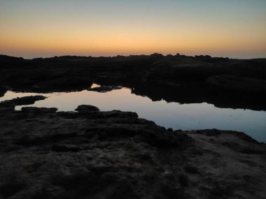 Görüntünün altında bir nehir bir vadi boyunca akar. Dik bir uçurumun nefes kesen manzarasını sağlar..