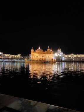 Resim, Hindistan 'ın Amritsar kentindeki ünlü bir Sih tapınağı olan Altın Tapınağı' nı renkli bir gece saatinde gösteriyor..