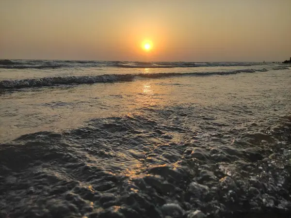 Okyanusun üzerinde güneş batarken deniz sıcacık parlıyor..