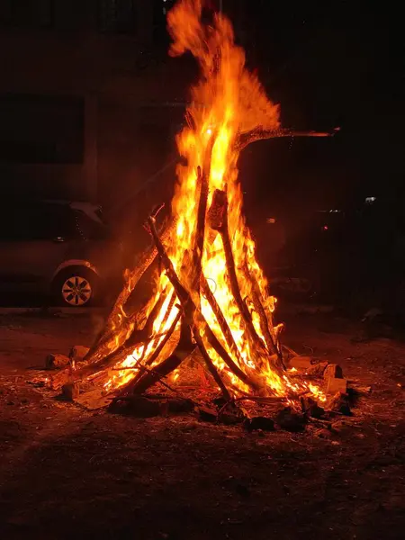 Parlak turuncu ve sarı alevleri olan büyük çatırdayan şenlik ateşi gece görüntülerinde görülebilir..