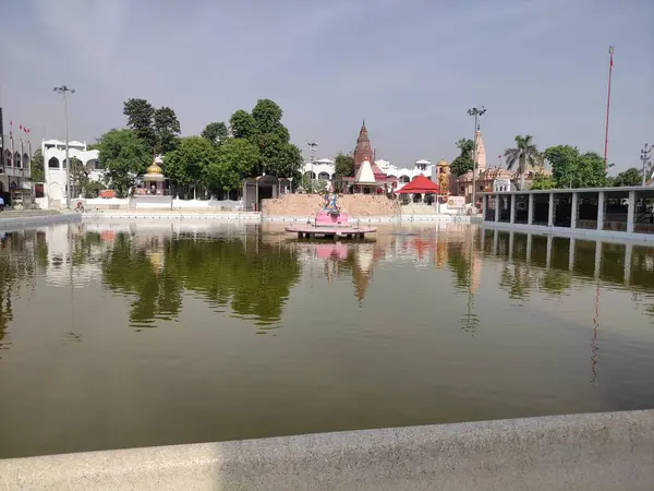 Merkezinde Tanrıça Saraswati heykeli olan sakin bir gölet, Dharamshala, Himachal Pradesh 'te bulunan bir tapınak ve ağaçlarla çevrili..