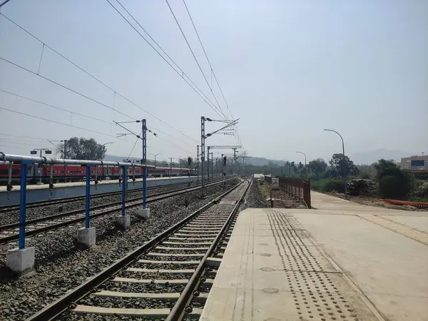 Platformda bir tren istasyonu ve resmin sağ tarafında bir tren yolu var. Platform boş ve kimse görünmüyor..