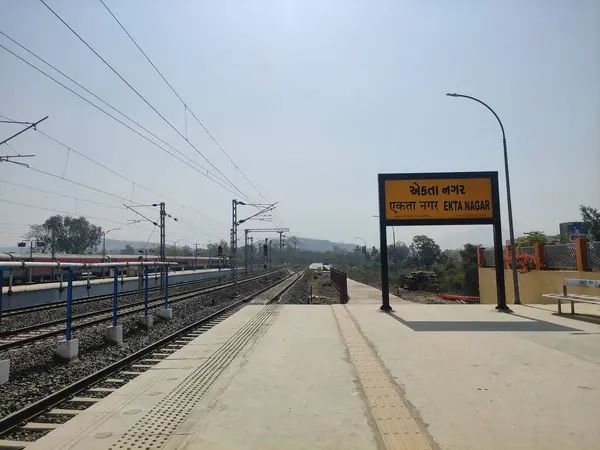 Fotoğrafın sağ tarafında bir tren yolu var ve platformun üzerinde de bir tren istasyonu. Kimse görünmüyor ve platform bomboş..