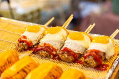 Japanese Pizza or Okonomiyaki roll with chopsticks fried egg topping ready to eat
