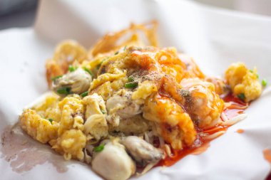 Chinese Oyster Omelette topped with sauce closeup