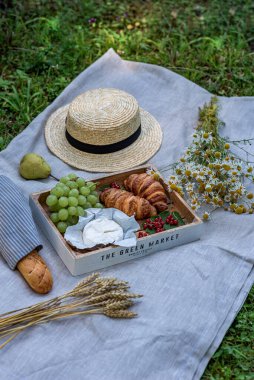 Summer picnic on the grass, bakery, fruits. Rest time, healthy food concept