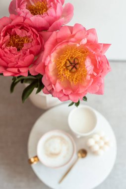 Cup with cappuccino, flowers peony, morning concept, soy candle, woman's day