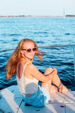 Yelkenlide oturan genç kadın, Yat, yaz zamanı, rahatla.