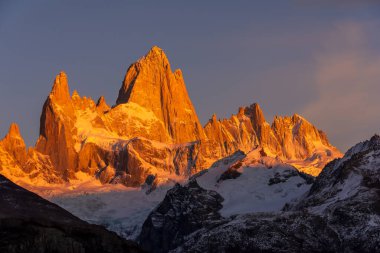 Fitz Roy dağında ilk güneş ışınları parlıyor, kırmızı ve turuncu renkler oluşturuyor. Fitz Roy, Arjantin 'in Patagonya bölgesinde El Chaltn köyünün yakınında yer almaktadır..