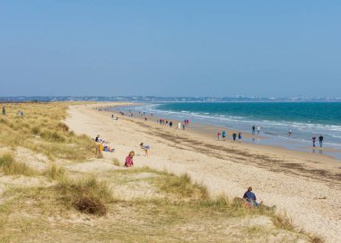 Studland Bay, Dorset, England - March 27, 2022: People enjoying Knoll Beach during a spring day on the south coast of England.