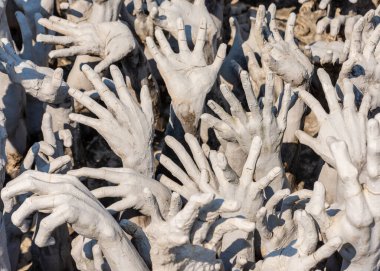 Chiang Rai, Thailand - February 10, 2019: A close up view of hands reaching out of hell at the White Temple (Wat Rong Khun) in Chiang Rai, Thailand.