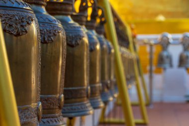 A row of bells lined up outside the Wat Phra Singh in Chiang Mai, Thailand.