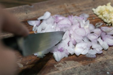 Ev mutfağında kırmızı soğan kesen bir kadının eli. Kırmızı soğan kesen kadına yakın çekim