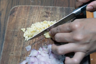 Ev mutfağında kırmızı soğan kesen bir kadının eli. Kırmızı soğan kesen kadına yakın çekim